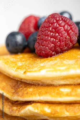 Pancakes with berries and maple syrup stock photo