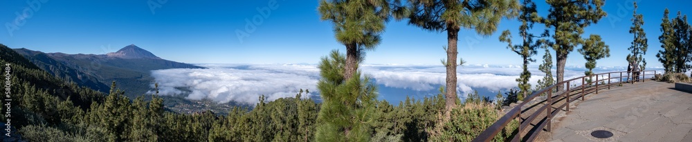Fototapeta premium Huge panorama shot of volcano el teide and its surroundings of clouds, trees and nature, in a sightseeing during summer in tenerife, spain