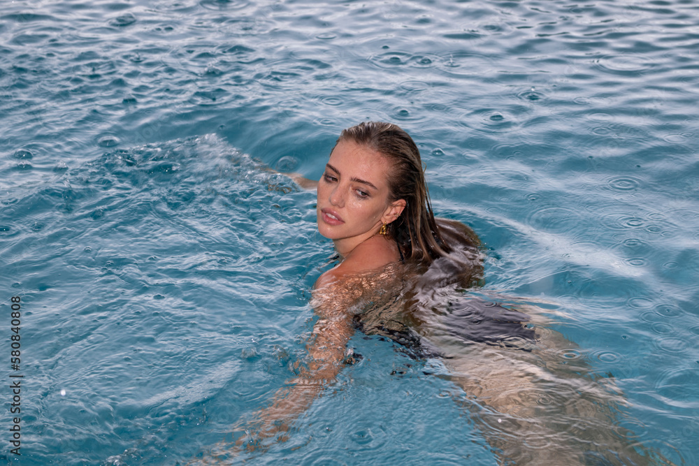 Rain in summer water. Sexy woman on Caribbean sea in Bahamas. Relax in spa swimming pool, refreshment. Miami. Beauty of woman on summer vacation and travel.
