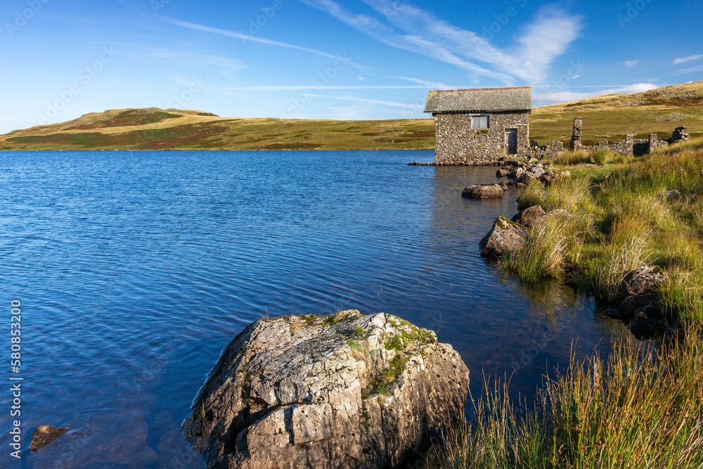 A beautiful old two-storey stone boathouse on the shores of Devoke Water in the Lake District National Park.