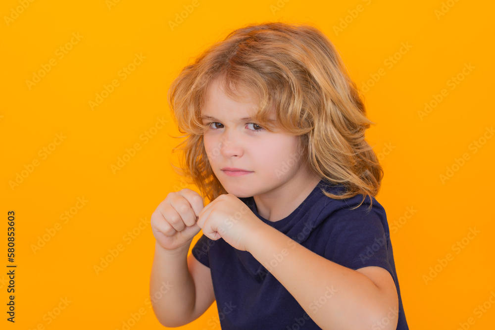 Angry child with fist gesture fight, hit on studio isolated background. Boy fight, battle. Kid boy with mad expression handed punch. Bad kids behavior. Fury boy. Angry child with fist gesture fight, hit on studio isolated background. Boy fight, battle. Kid boy with mad expression handed punch. Bad kids behavior. Fury boy.