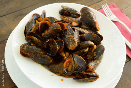 Plate with mediterranean seafood dish black shell mussels with sauce