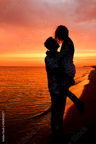 silhouette of a happy couple at sunrise on summer nature