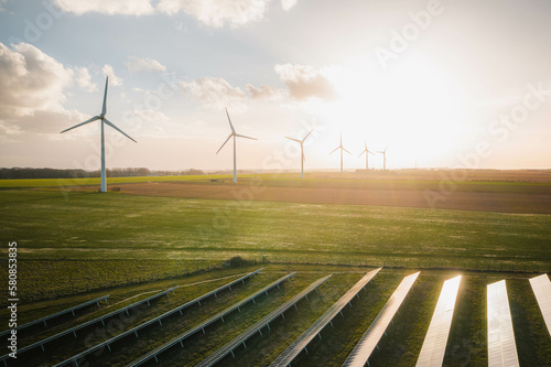 Wind turbines and solar panels farm in a field. Renewable green energy. Sunny landscape, electric energy generator for clean energy producing concept.