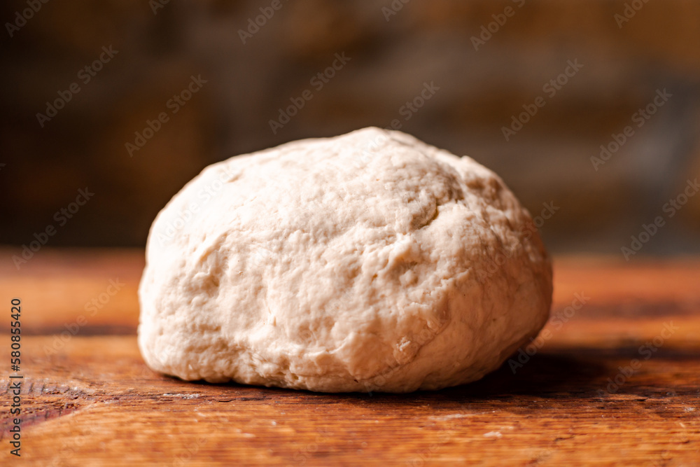 Yeast dough ball on wooden background. Cooked dough for baking pizza or bread. Yeast dough ball on wooden background. Cooked dough for baking pizza or bread.