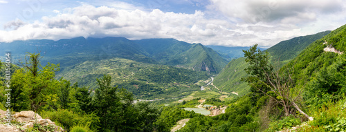 Tskhenistsqali river valley panorama in Racha region of Georgia with Svaneti mountain range, lush green forests and vineyards seen from to Khvamli Mountain. photo