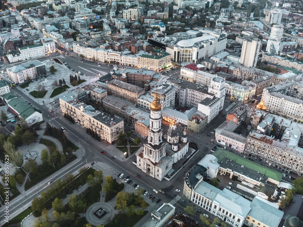 Aerial look down view on Dormition Cathedral near Independence square in evening lights of Kharkiv city downtown, Ukraine.