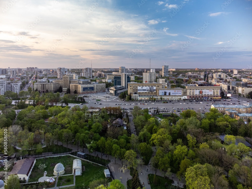Aerial view on Svobody Square and historic buildings from park with sunset sky. Kharkiv, Ukraine in spring
