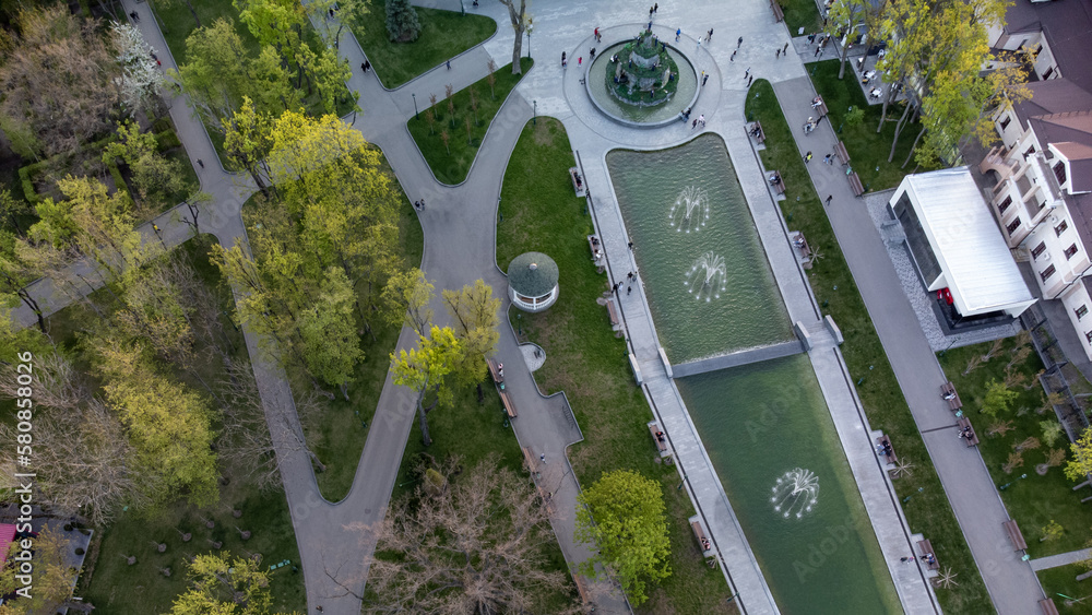 Aerial look down view on fountains in green spring Shevchenko City Garden. Tourist attraction in modern city park, recreation in Kharkiv, Ukraine