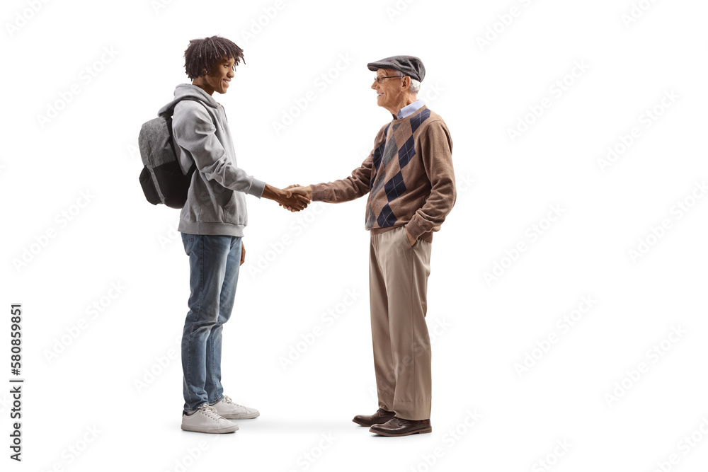 Full length profile shot of an african american male student and a caucasian senior man shaking hands Full length profile shot of an african american male student and a caucasian senior man shaking hands