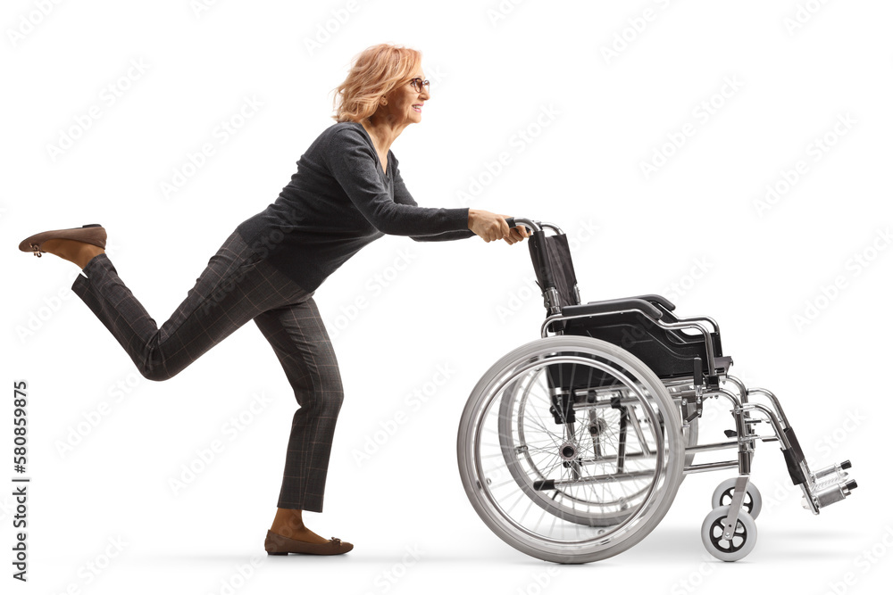 Full length profile shot of a mature woman running and pushing an empty wheelchair Full length profile shot of a mature woman running and pushing an empty wheelchair