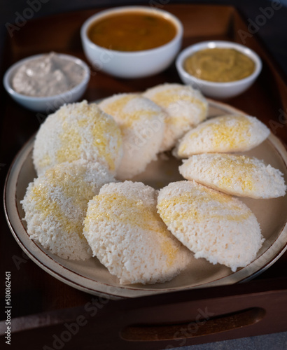 Close up of Idly a south Indian famous healthy steam cooked breakfast. Traditionally served idly with chutneys and sambar. Sprinkled home made clarified butter or Ghee on idly.
