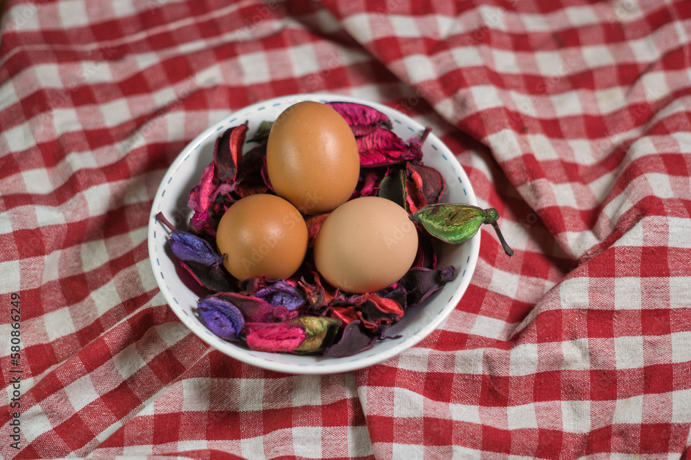 Three eggs on a bed of flower petals in a bowl Three eggs on a bed of flower petals in a bowl
