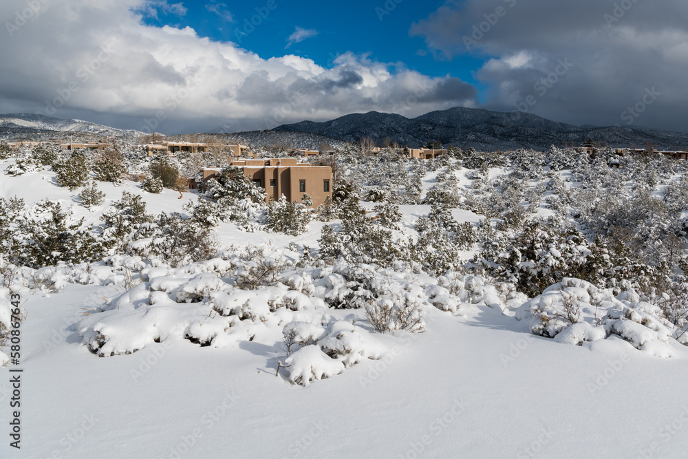 Adobe homes in a snowy winter landscape in Santa Fe, New Mexico