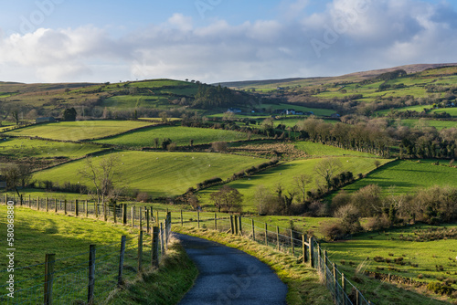 Road curving through green fields and hills in the Glens of Antrim photo
