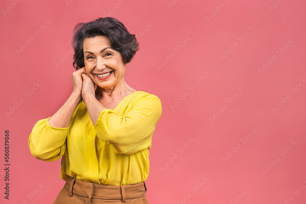 Senior happy aged business woman. Beautiful old woman, grandmother looking at camera and smiling. Isolated on pink background. Senior happy aged business woman. Beautiful old woman, grandmother looking at camera and smiling. Isolated on pink background.