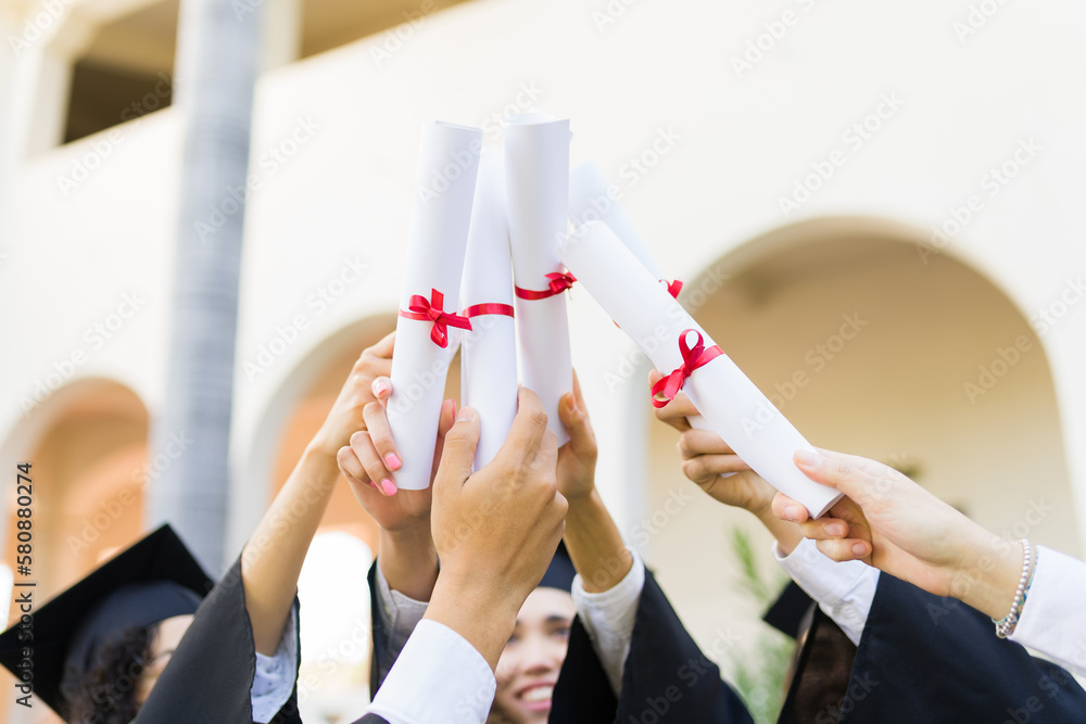Graduates holding their college diplomas