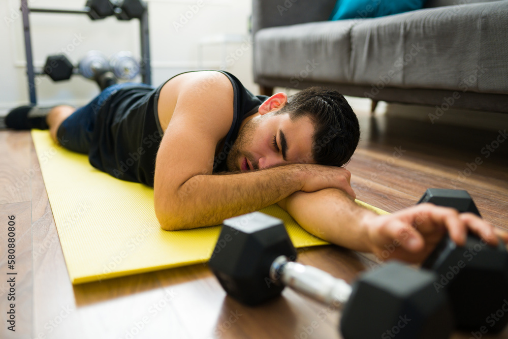 Tired young man exhausted from his home workout Tired young man exhausted from his home workout