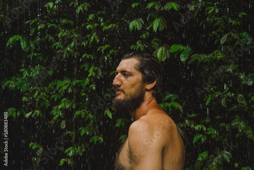 Naked man at a tropical waterfall, Bali.