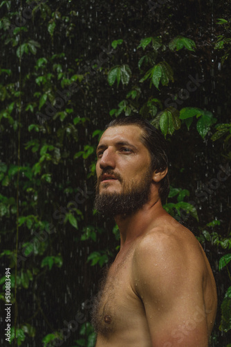 Naked man at a tropical waterfall, Bali.