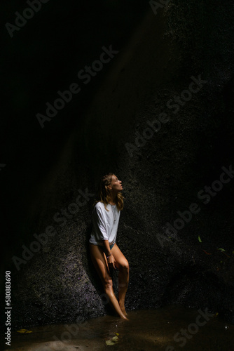 Woman tourist at a waterfall in the tropical jungle, Bali. © Yuliya Kirayonak
