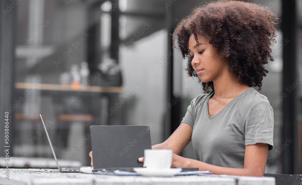 Shot of a young business african american woman reading a text while sitting at an outdoor cafe. Shot of a young business african american woman reading a text while sitting at an outdoor cafe.