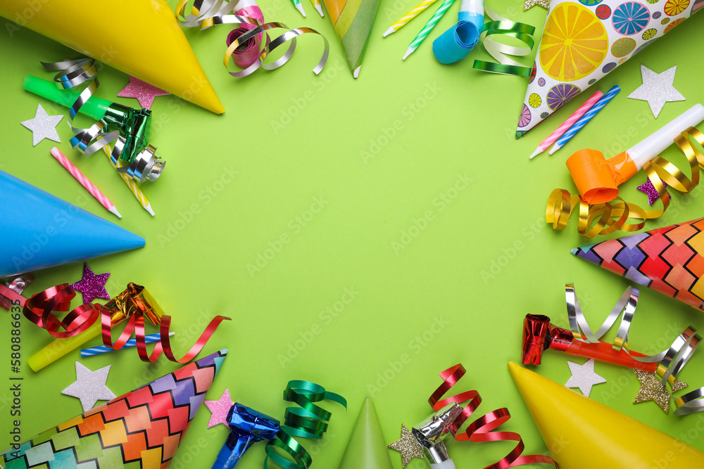 Obraz premium Frame of different accessories for birthday party on green background, flat lay. Space for text