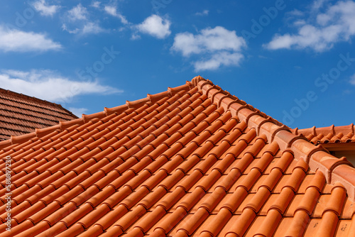 Red tiles panels roof under blue sky. photo