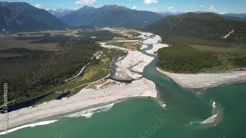 Outstanding aerial view of Mahitahi river delta entering Pacific Ocean. Wild nature New Zealand landscape. photo