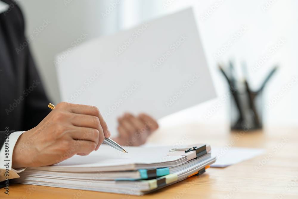 Financial advisor, analyst, asian businesswoman pointing at financial statistics report paper business income Taxes piled up on the desk to validate presentations at office meetings. - obrazy, fototapety, plakaty 