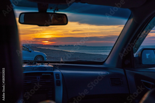View of the sunset from the car window on the seashore