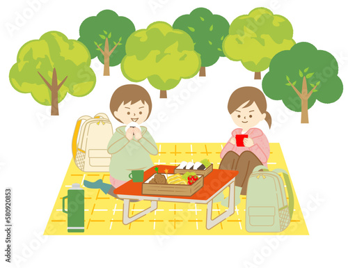 ハイキングに来てレジャーシートを広げ、お弁当を食べる若い女性