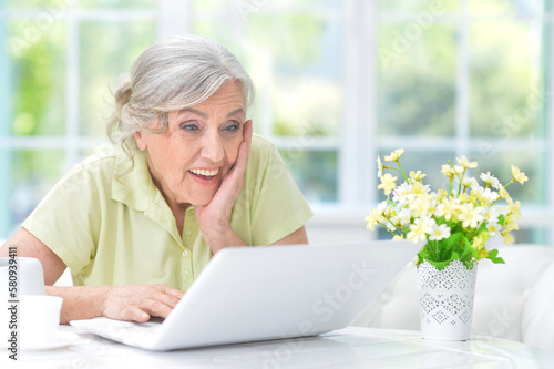 old nice woman using laptop at home