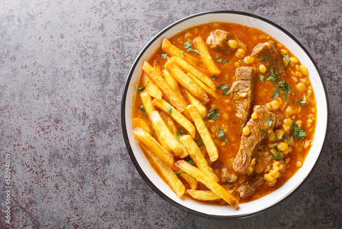 Khoresh Gheymeh yellow split peas, saffron, tomato paste, diced meat, and sun-dried lime are the main ingredients of this delicious stew closeup on a plate on the table. Horizontal top view from above photo