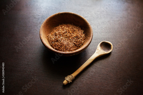 High angle view of herbs in wooden bowl with spoon on table photo
