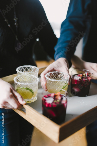 Midsection of woman serving drinks to male friend in party at home photo