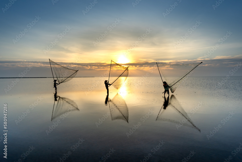 Fototapeta premium The image of fishermen in fishing village using homemade tools to catch clam at sea at dawn at Diem Dien beach, Thai Thuy commune, Thai Binh province, Vietnam
