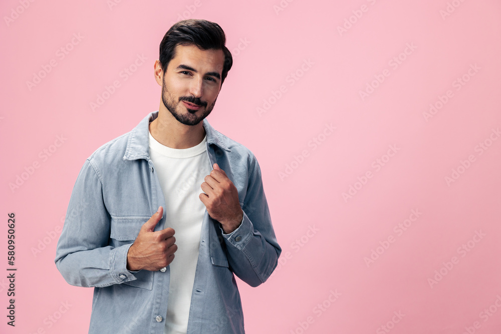 Portrait of a stylish brunette man with a beard beautiful smile on a pink background in a white T-shirt and jeans smile and joyful emotion on his face, copy space Portrait of a stylish brunette man with a beard beautiful smile on a pink background in a white T-shirt and jeans smile and joyful emotion on his face, copy space