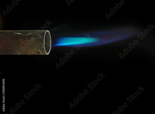 blue flame coming out of a blowtorch on a black background