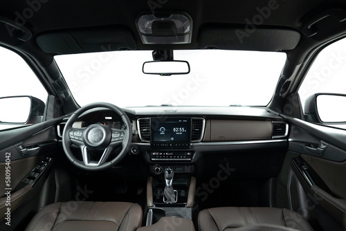 Dark luxury car Interior - steering wheel, shift lever and dashboard. Car inside. Beige comfortable seats, steering wheel, dashboard, climate control, speedometer, display. © tanleimages.com
