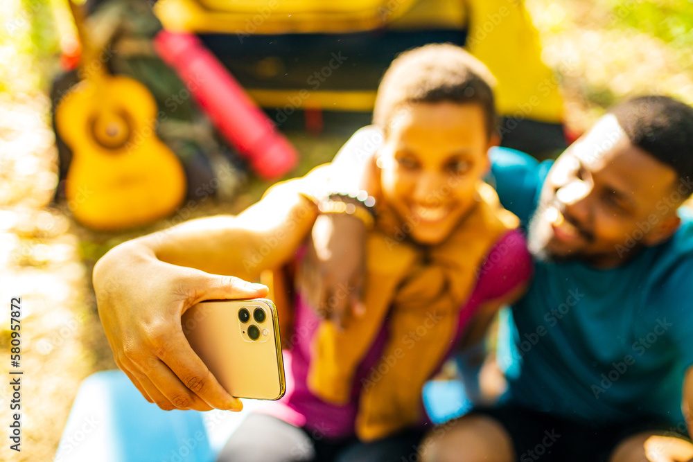 afro latin couple in tent taking selfie using modern smartphone afro latin couple in tent taking selfie using modern smartphone