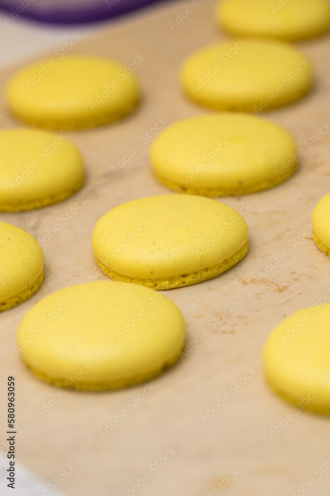 Obraz premium yellow halves for macaroons cookies on the table. home bakery concept.