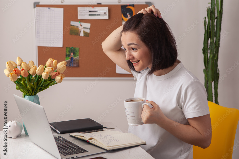 Happy casual beautiful woman working on a laptop in the house. Happy casual beautiful woman working on a laptop in the house.