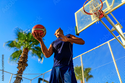 turkish man playing basket ball outdoor in summer day blue sky background