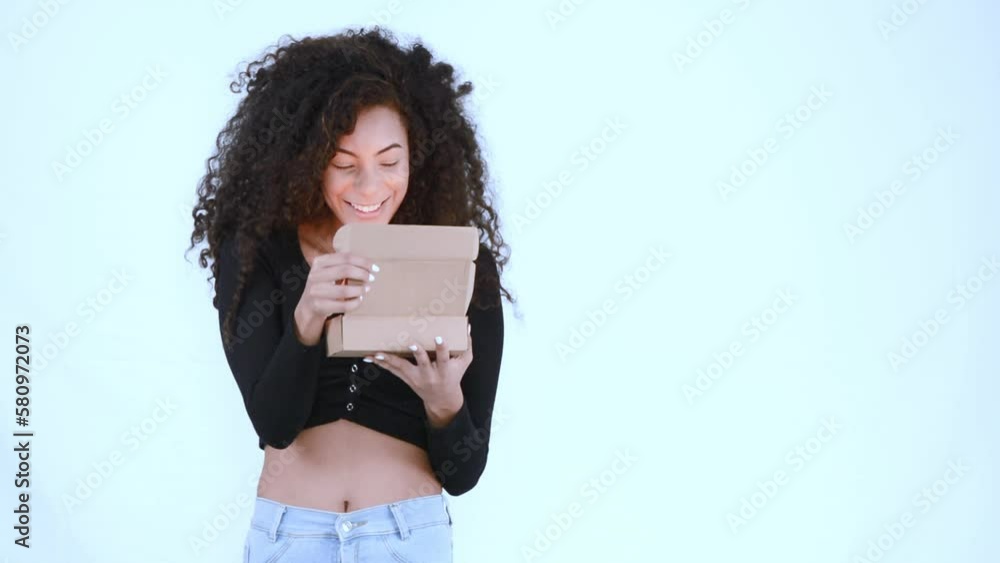 Excited young Latina woman opening a parcel box. Excited young Latina woman opening a parcel box.