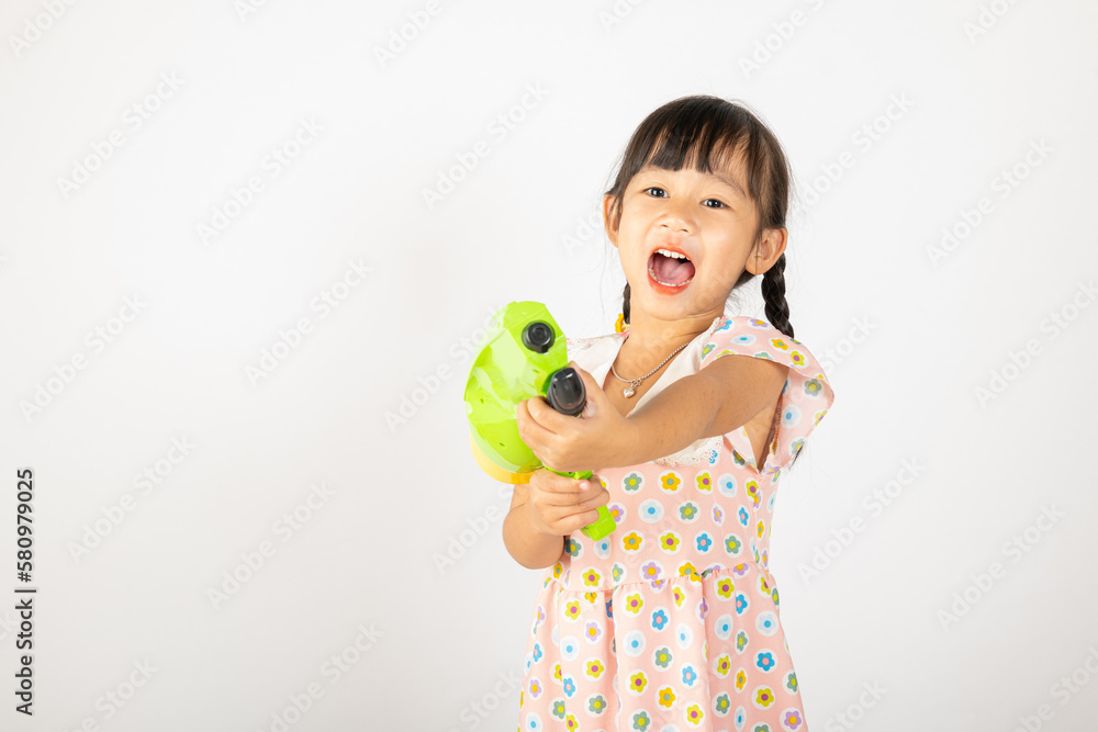 Happy Songkran Day, Asian little girl holding plastic water gun, Thai child funny hold toy water pistol and smile, isolated on white background, Thailand Songkran festival national culture concept Happy Songkran Day, Asian little girl holding plastic water gun, Thai child funny hold toy water pistol and smile, isolated on white background, Thailand Songkran festival national culture concept