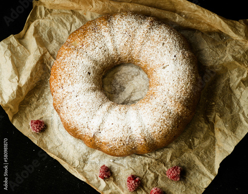 Vanilla bundt cake with fresh raspberries on a black table. vegetarian, lean, dairy and egg free. Top view. Copy space. Selective focus. Close up