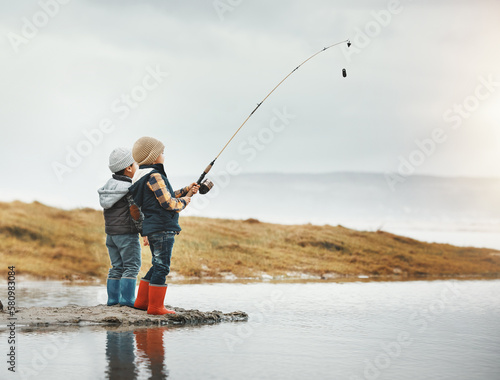 Lake, activity and children fishing while on vacation, adventure or weekend trip for a hobby. Outdoor, nature and boy siblings or kids catching fish in water together while on holiday in countryside.