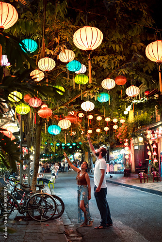 Photos Backpacker couple enjoy trip through Southeast Asia while visiting Hoi An city,