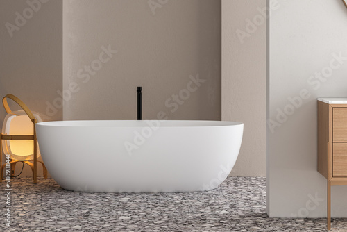 Stylish white bathtub on terrazzo floor with back faucet in bright bathroom  beige and white wall background. 3d Rendering
